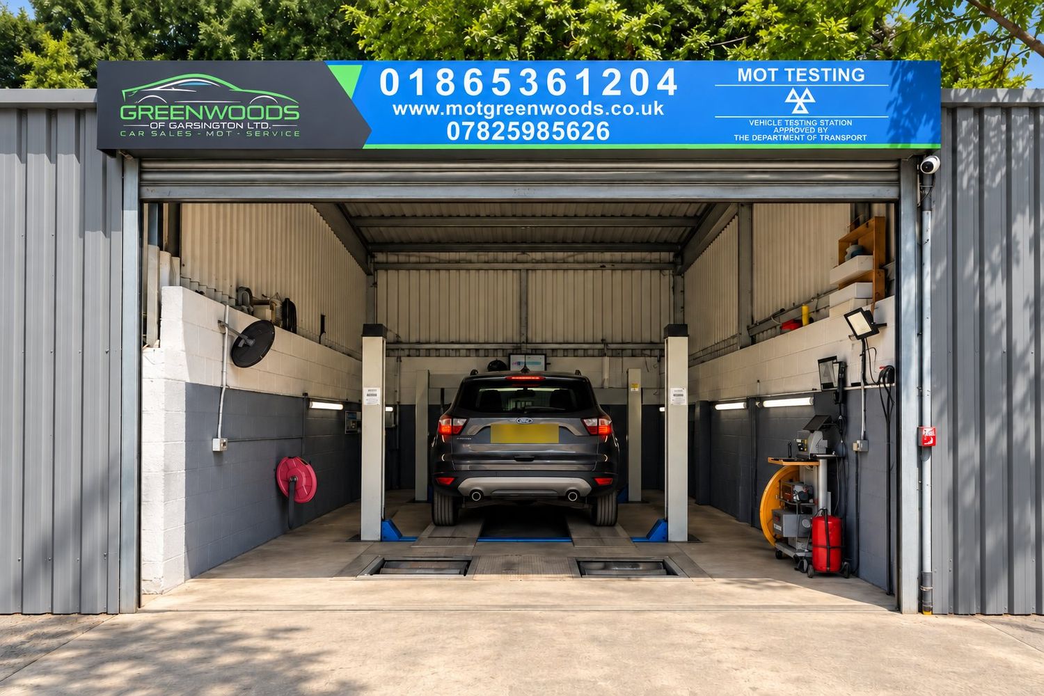 Greenwoods MOT testing station in Garsington, with a car on the MOT lift